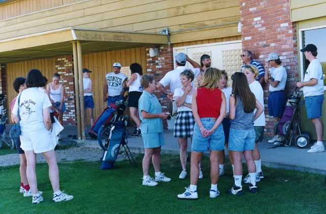 Golf tournament participants wait to tee off on the first hole.